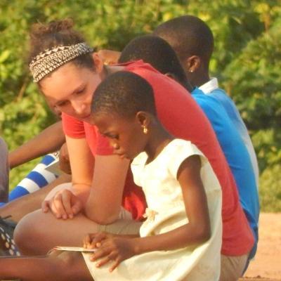 An intern reads with a child during her Social Work internship in Ghana. A Projects Abroad intern gains social work experience in Ghana by working through activities with a child.